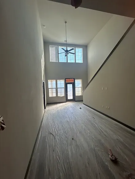 High-ceiling living room with newly painted walls and protected floors during a Phoenix interior paint job